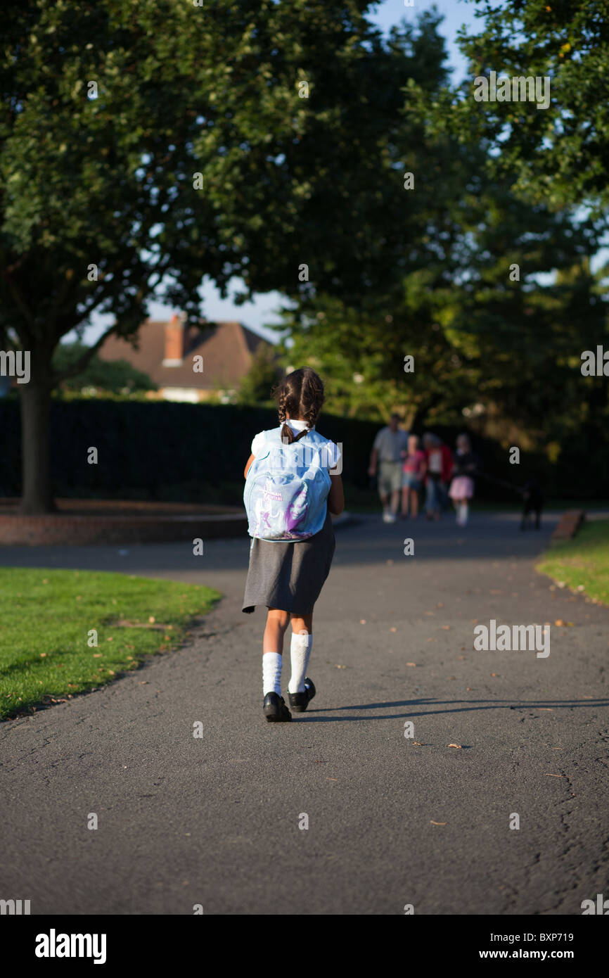 Fille qui marche à la maison de l'école Banque D'Images