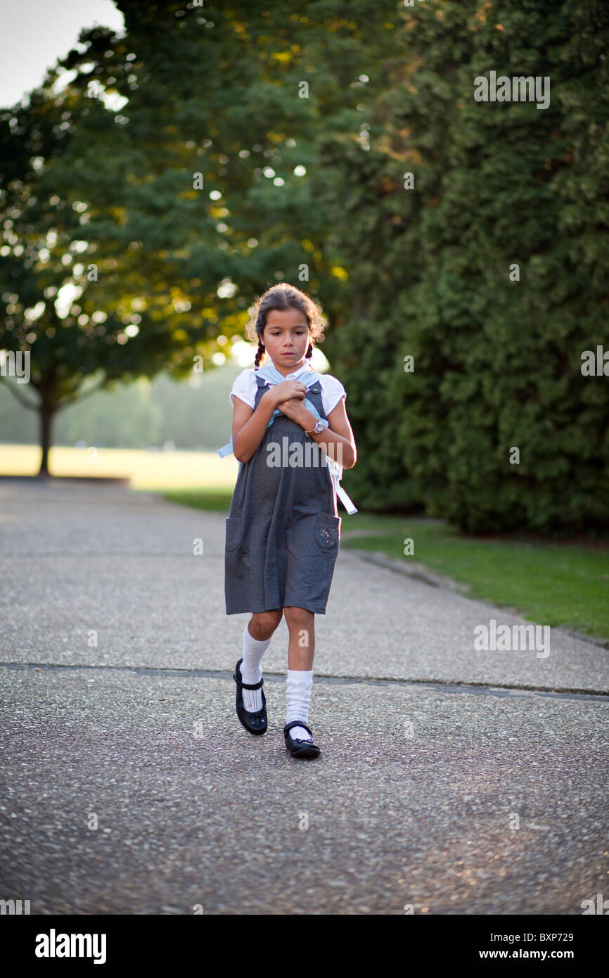 Fille qui marche à la maison de l'école Banque D'Images