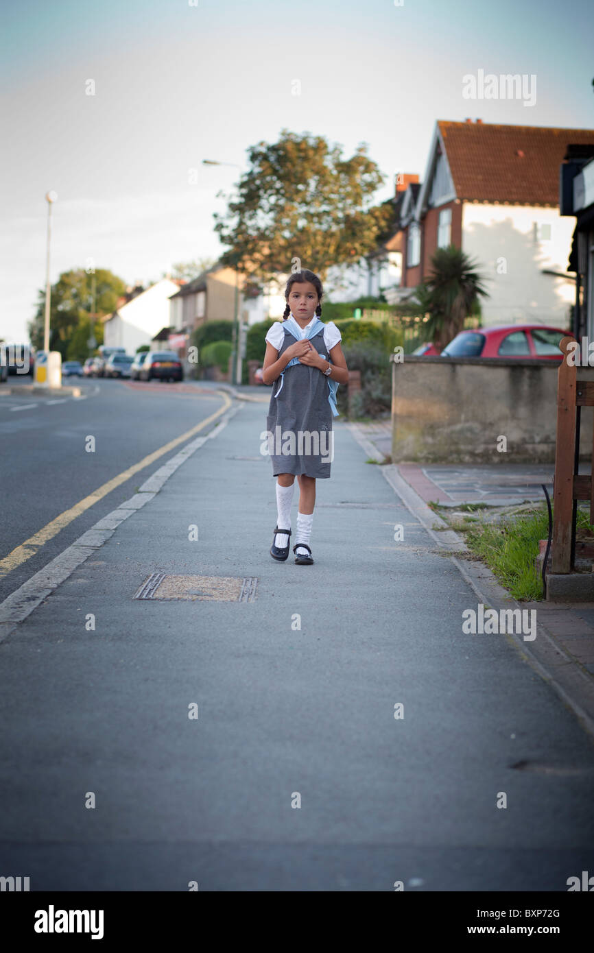 Fille qui marche à la maison de l'école Banque D'Images