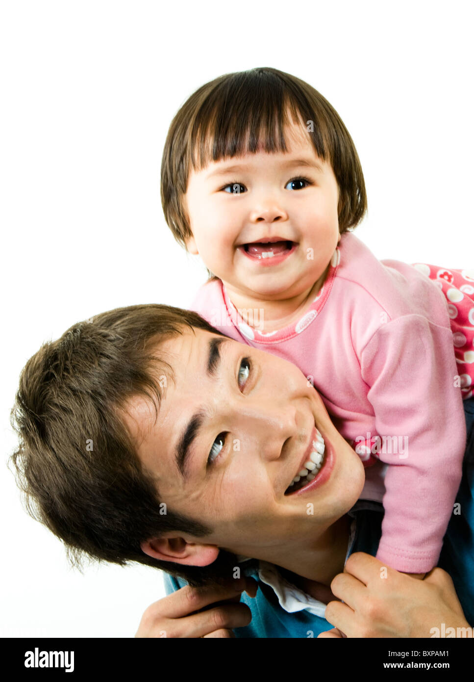Photo de happy little girl au dessus de son père pendant qu'il la tenant par les mains et rire Banque D'Images