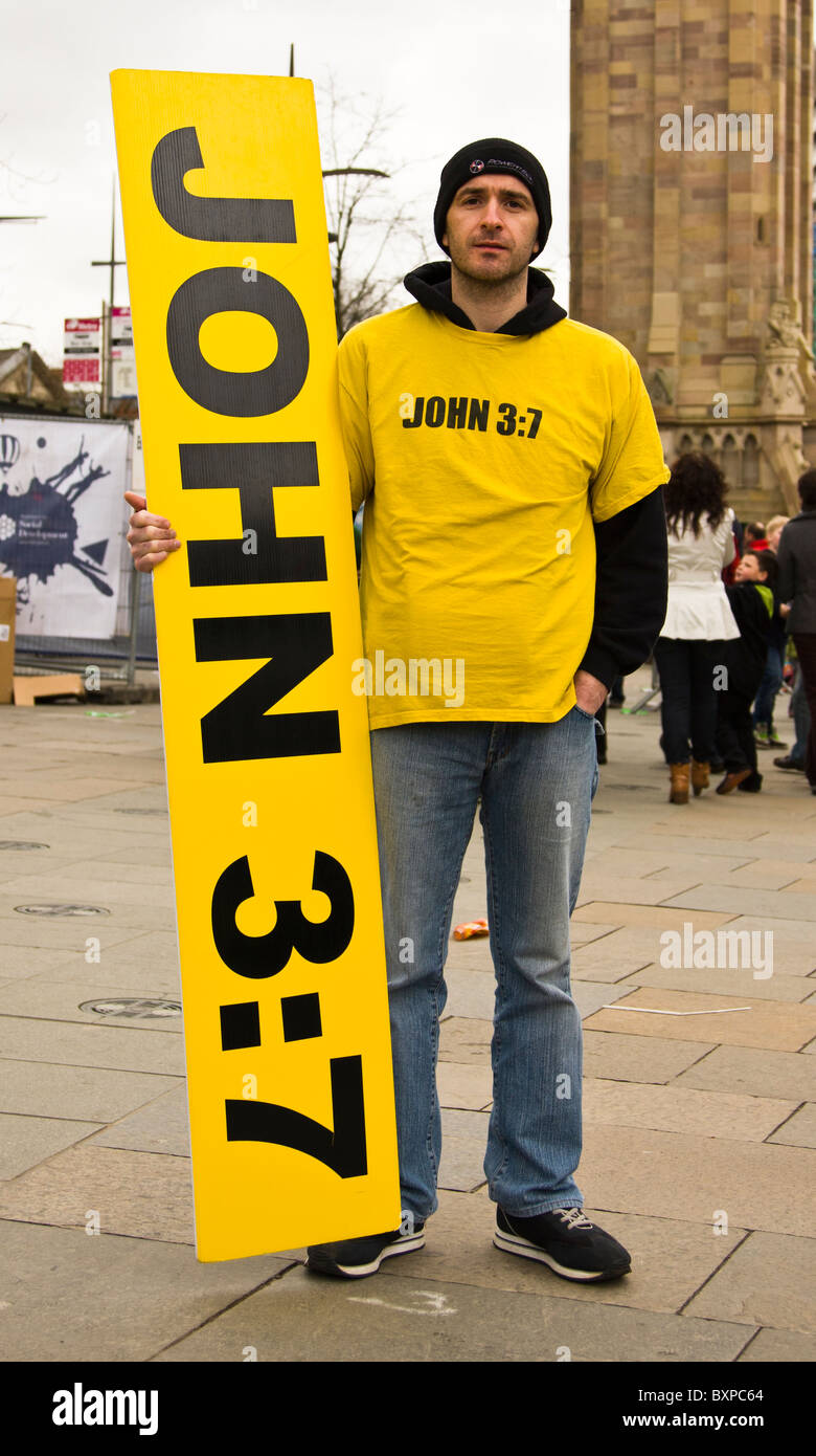 Man holding sign citant Jean 3:1. "Vous devez naître de nouveau" Banque D'Images
