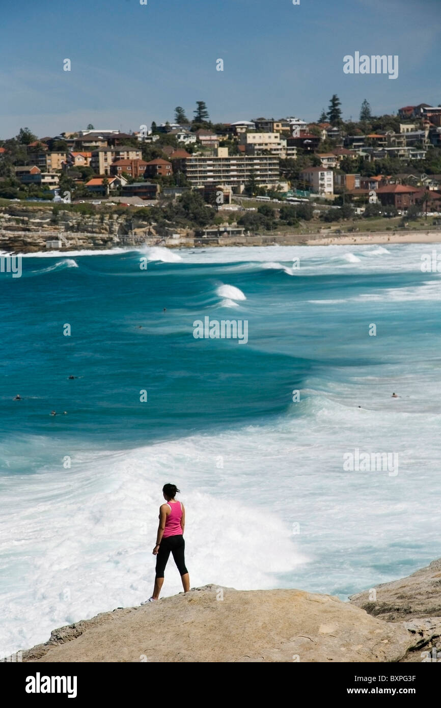 Femme Debout sur le roc Sur Mackensies et Tamarama Bay, près de Bondi Beach Banque D'Images