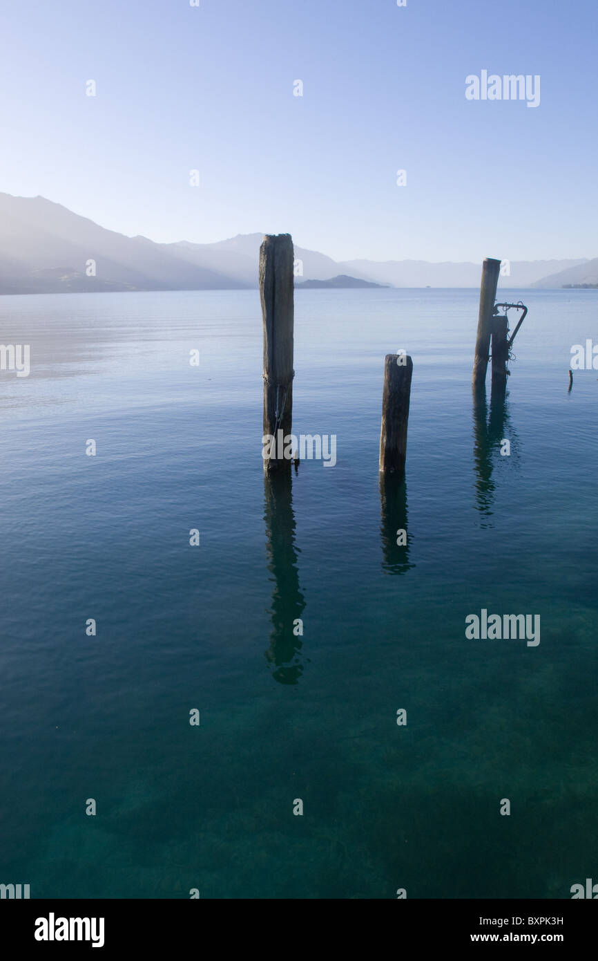 Messages d'une ancienne jetée avec reflets dans les eaux calmes du lac Wakatipu tôt le matin Banque D'Images