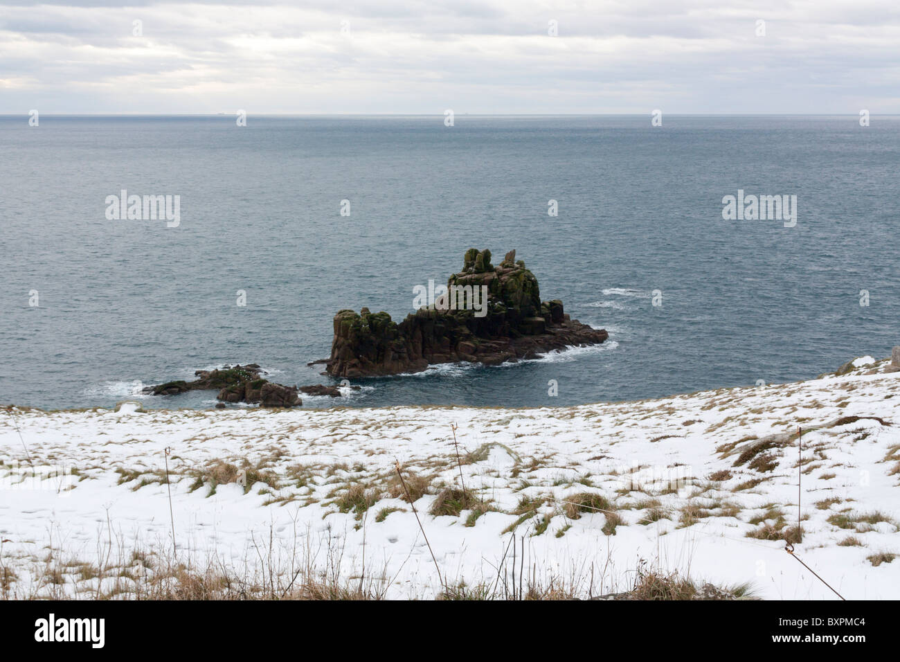 Neige à Lands End avec le chevalier armé rock formation près de la côte ; Cornwall England UK Banque D'Images