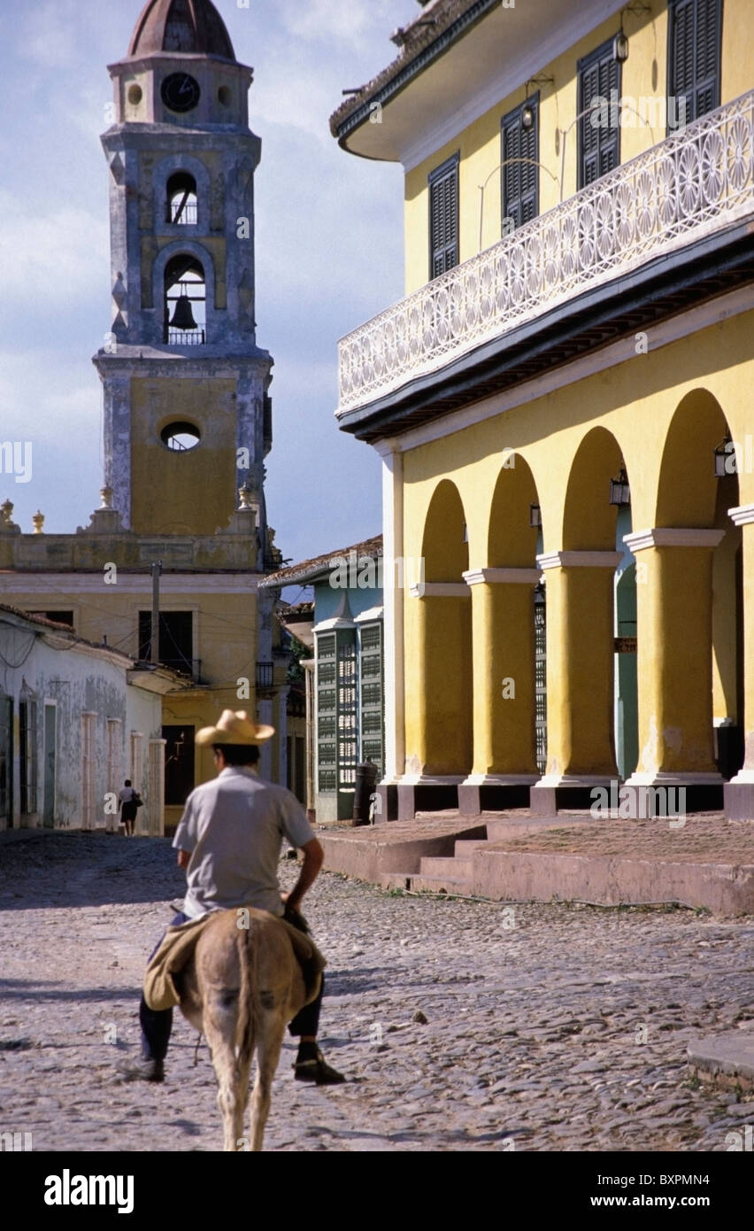 Man Riding Horse près de bâtiments coloniaux Banque D'Images