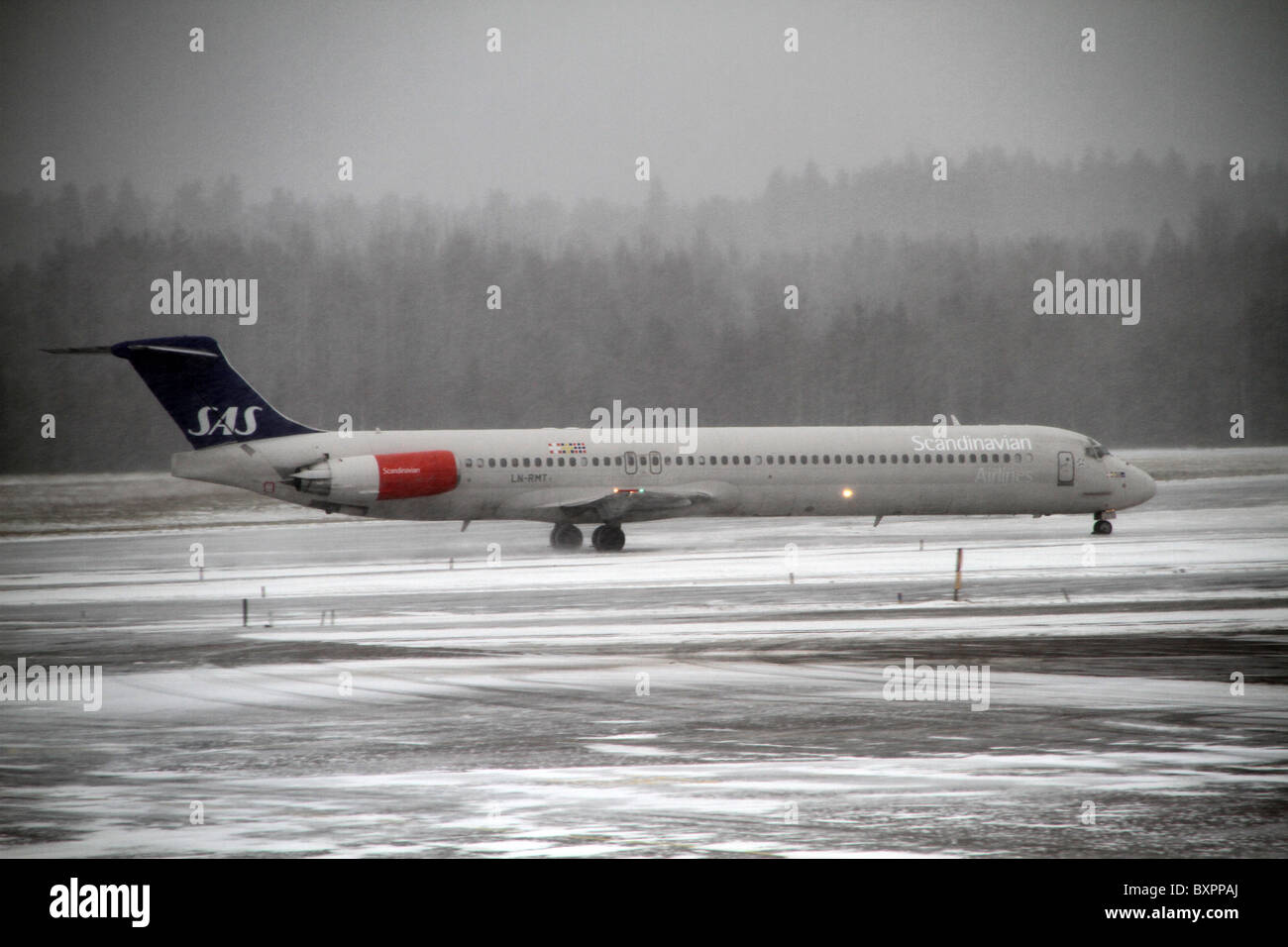 L'aéroport d'Arlanda, Stockholm, Suède. Un avion SAS sur le tarmac de neige un jour brumeux et relié à l'aéroport d'Arlanda. Banque D'Images