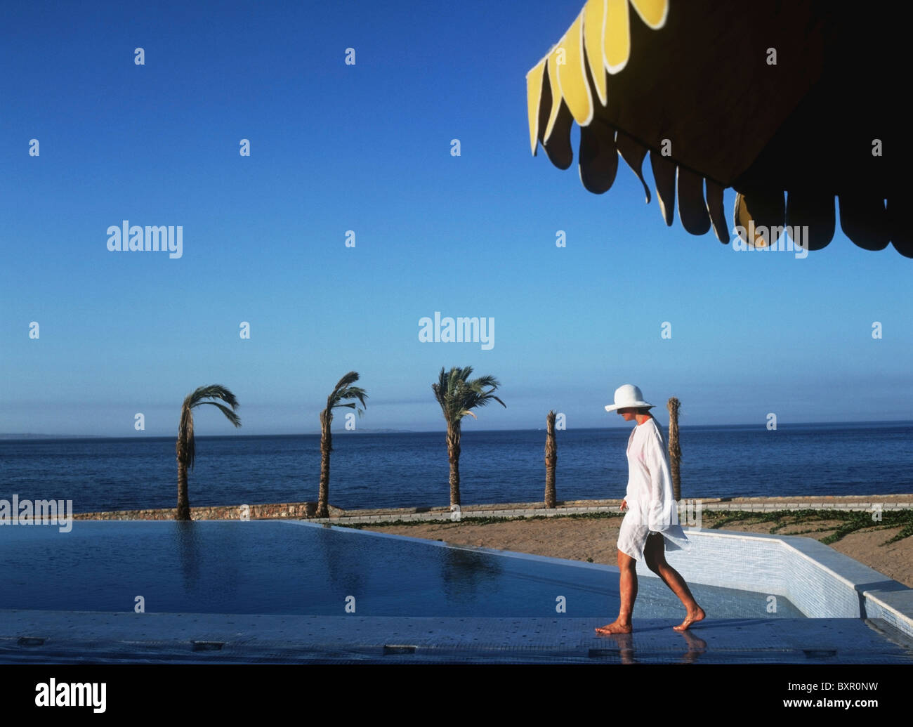 Femme au chapeau de soleil et plage le long d'Éveil Kaftan à Oberoi Sahl Hasheesh Resort Banque D'Images