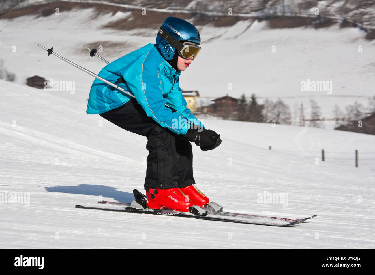 Enfant portant un casque de ski de descente rapide ski pistes de ski sur la neige dans les Alpes autrichiennes. Rauris Autriche Europe. Banque D'Images