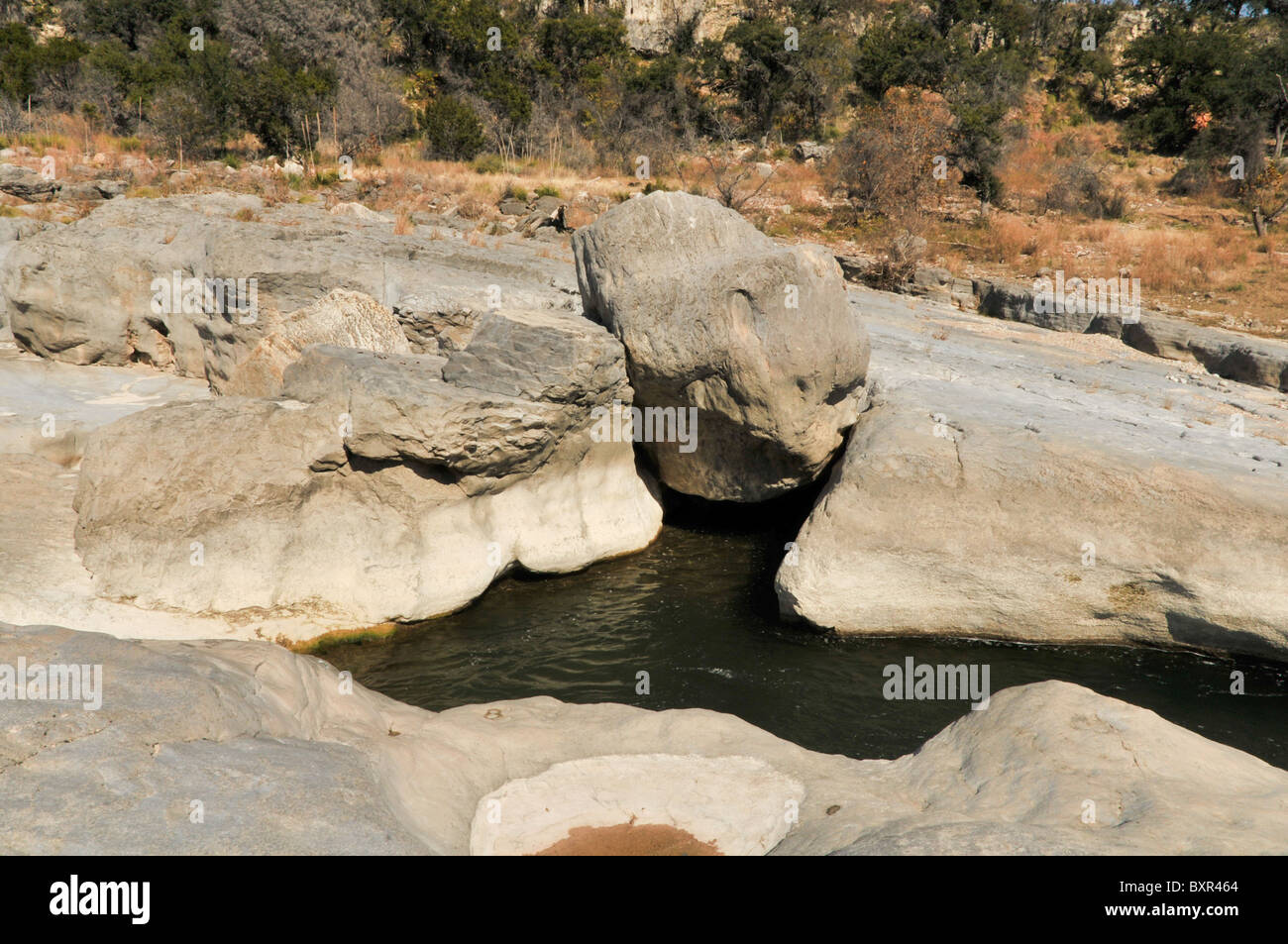 Gros rocher coincé en fissure dans les roches paléozoïques exposés dans Pedernales Falls State Park, Johnson City, Texas Banque D'Images