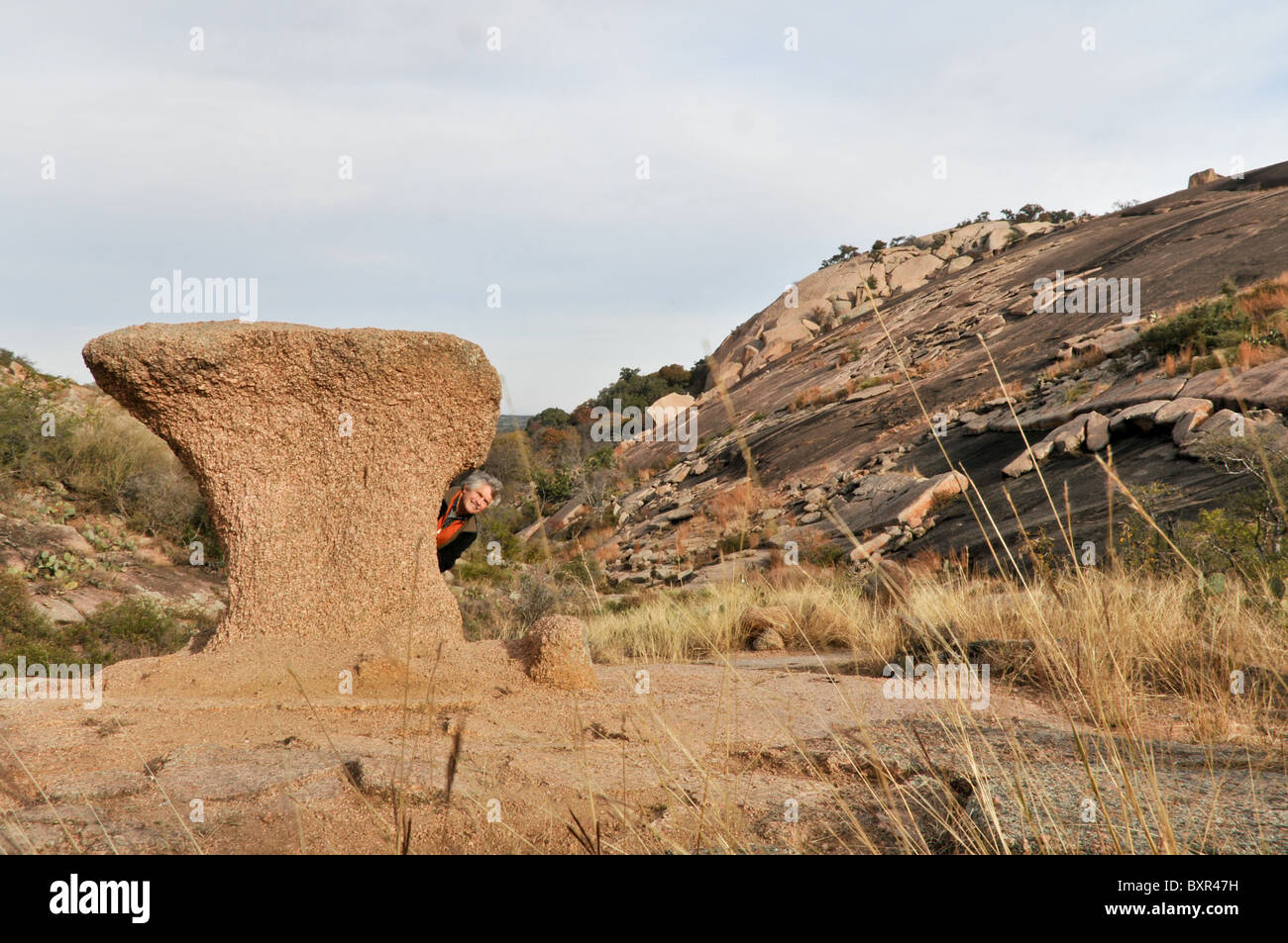L'homme sur le site de l'arrière de la formation rocheuse inhabituelle sur le batholite de granite, Enchanted Rock Natural Area, Fredricksburg, Texas Banque D'Images