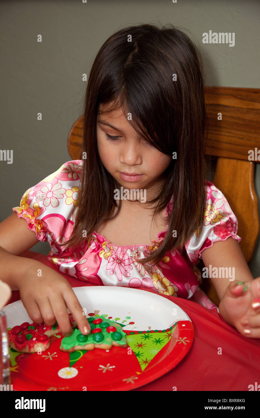 White/Filipino girl décore un biscuit de Noël Banque D'Images