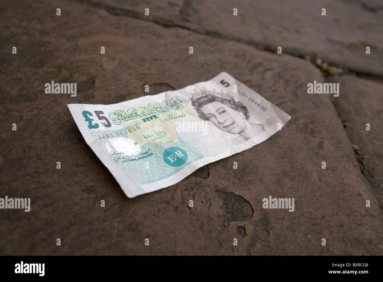 5 5 livre sterling bank note sur les trottoirs Banque D'Images