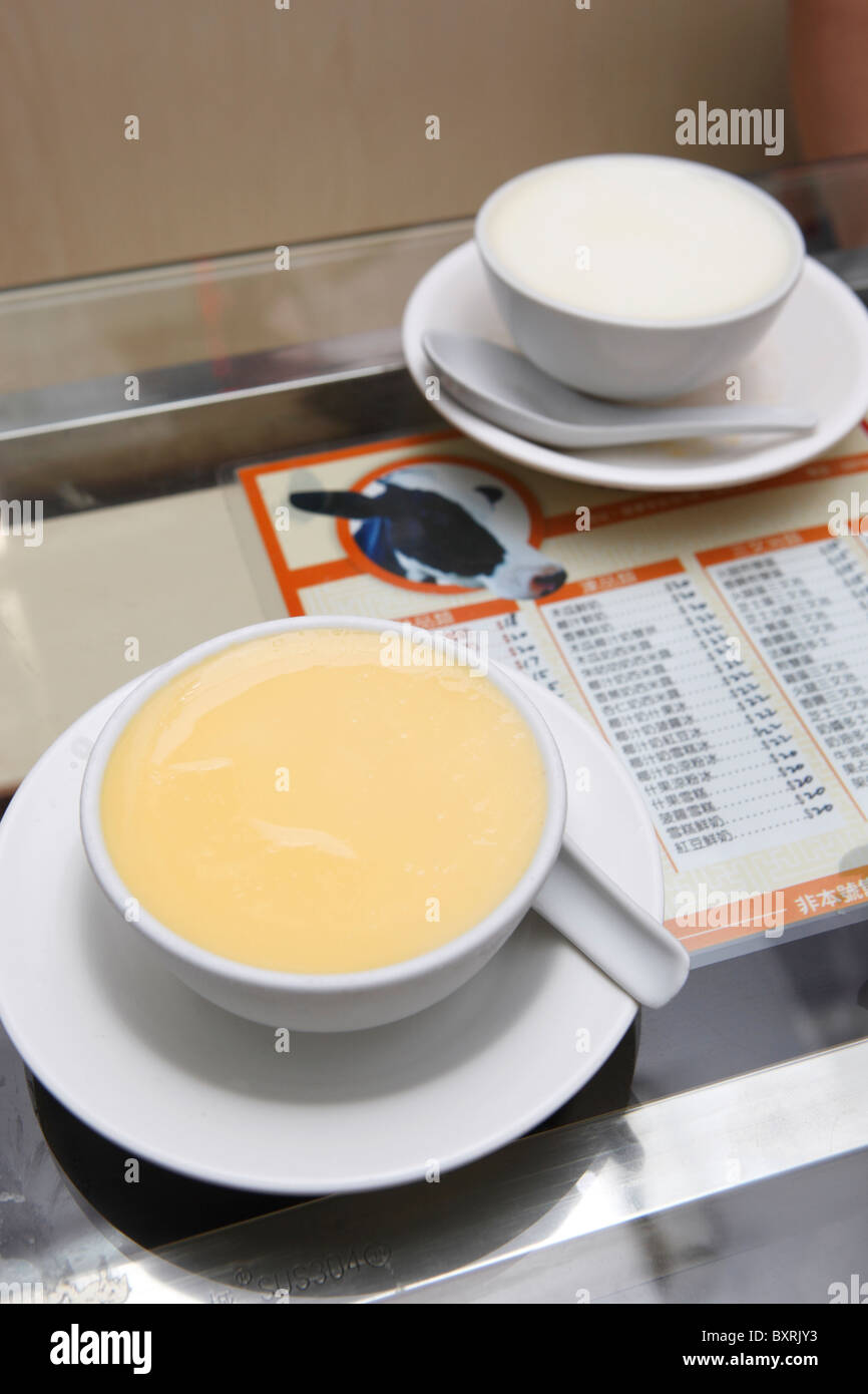 Pouding au lait cuit à la chinoise (retour) et d'oeufs au lait (avant) dans un café à Macao Banque D'Images