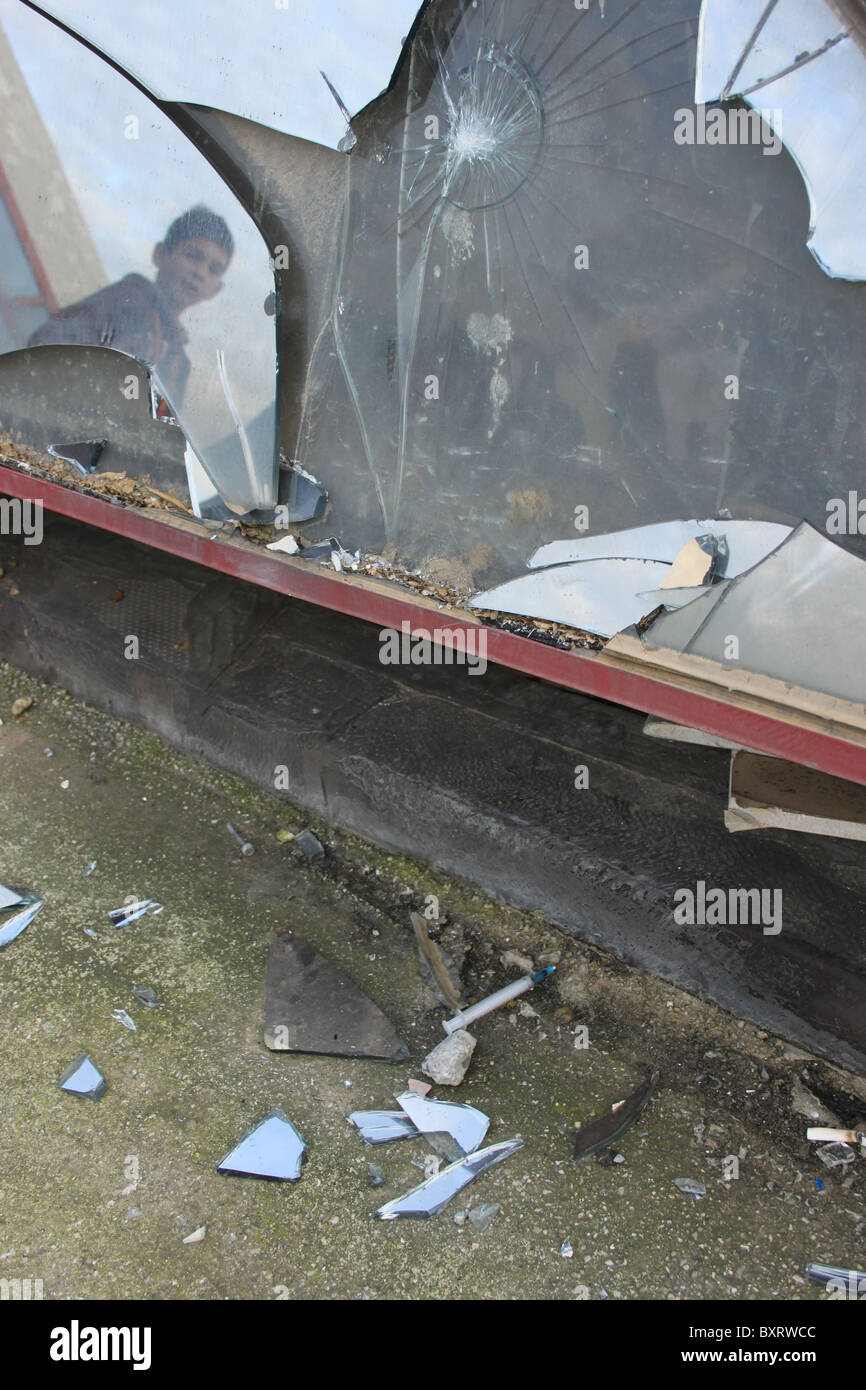 Un jeune garçon regarde une aiguille laissée par un utilisateur de drogue par un bâtiment abandonné à Tirana, Albanie Banque D'Images