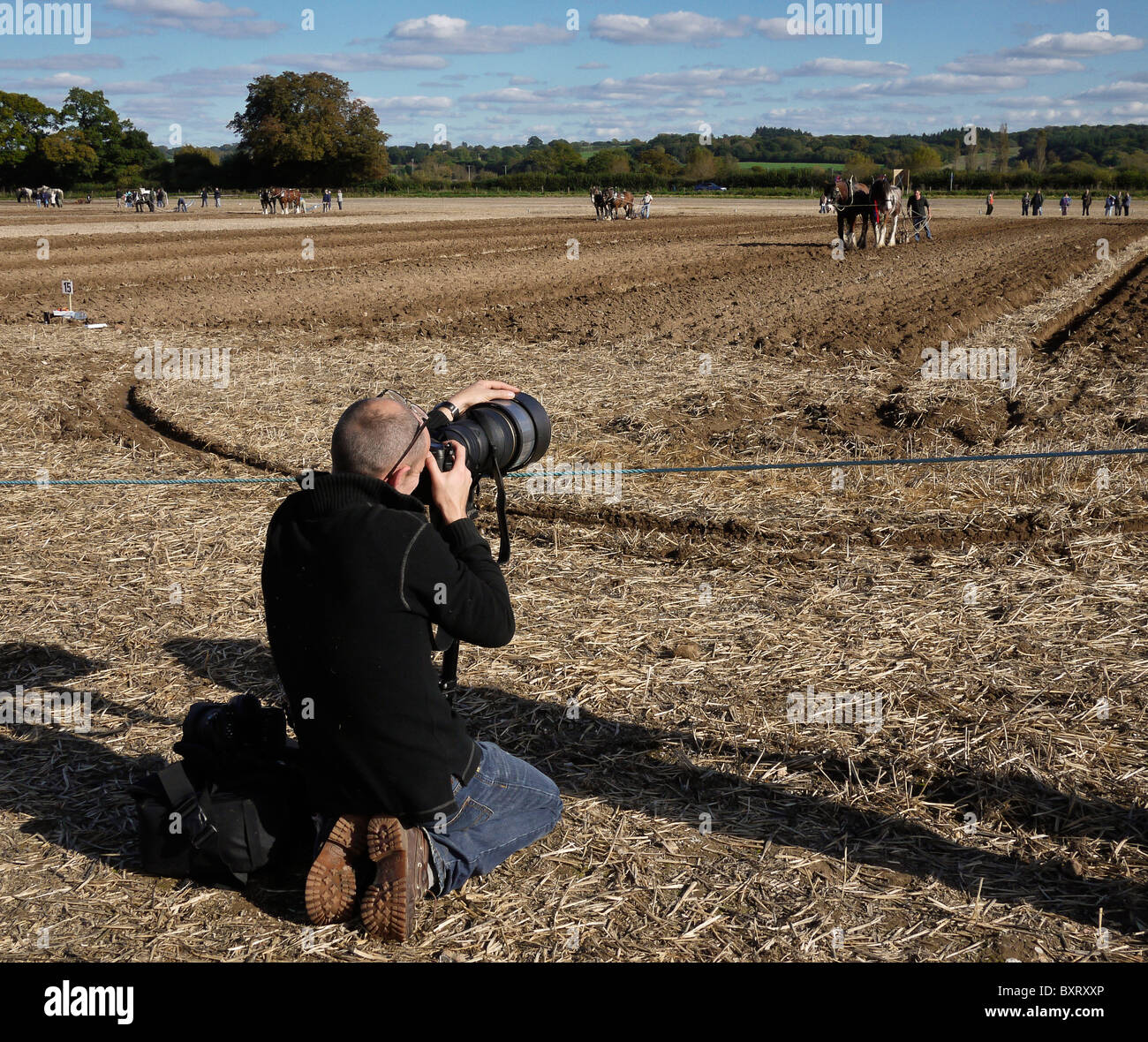 Photographe en action utilisant une monopode à un Plawing Match, Hampshire, Royaume-Uni Banque D'Images