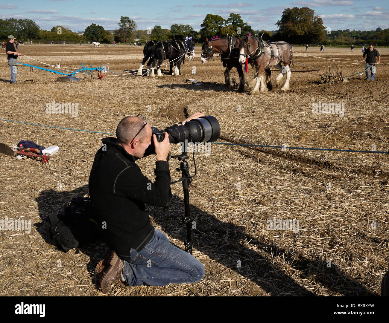 Photographe en action utilisant une monopode à un Plawing Match, Hampshire, Royaume-Uni Banque D'Images