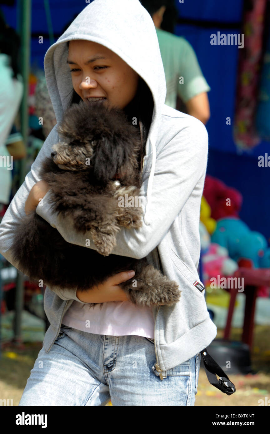 Jeune fille thaïe avec son chien de compagnie , les champs de tournesols de Lopburi, Thaïlande centrale Banque D'Images