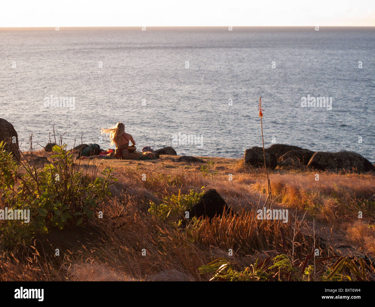 Près d'une femme, ou le site heiau ancient temple Hawaiien donnant sur l'océan au-dessus de Kalalau beach, côte de Na Pali, Kauai Banque D'Images