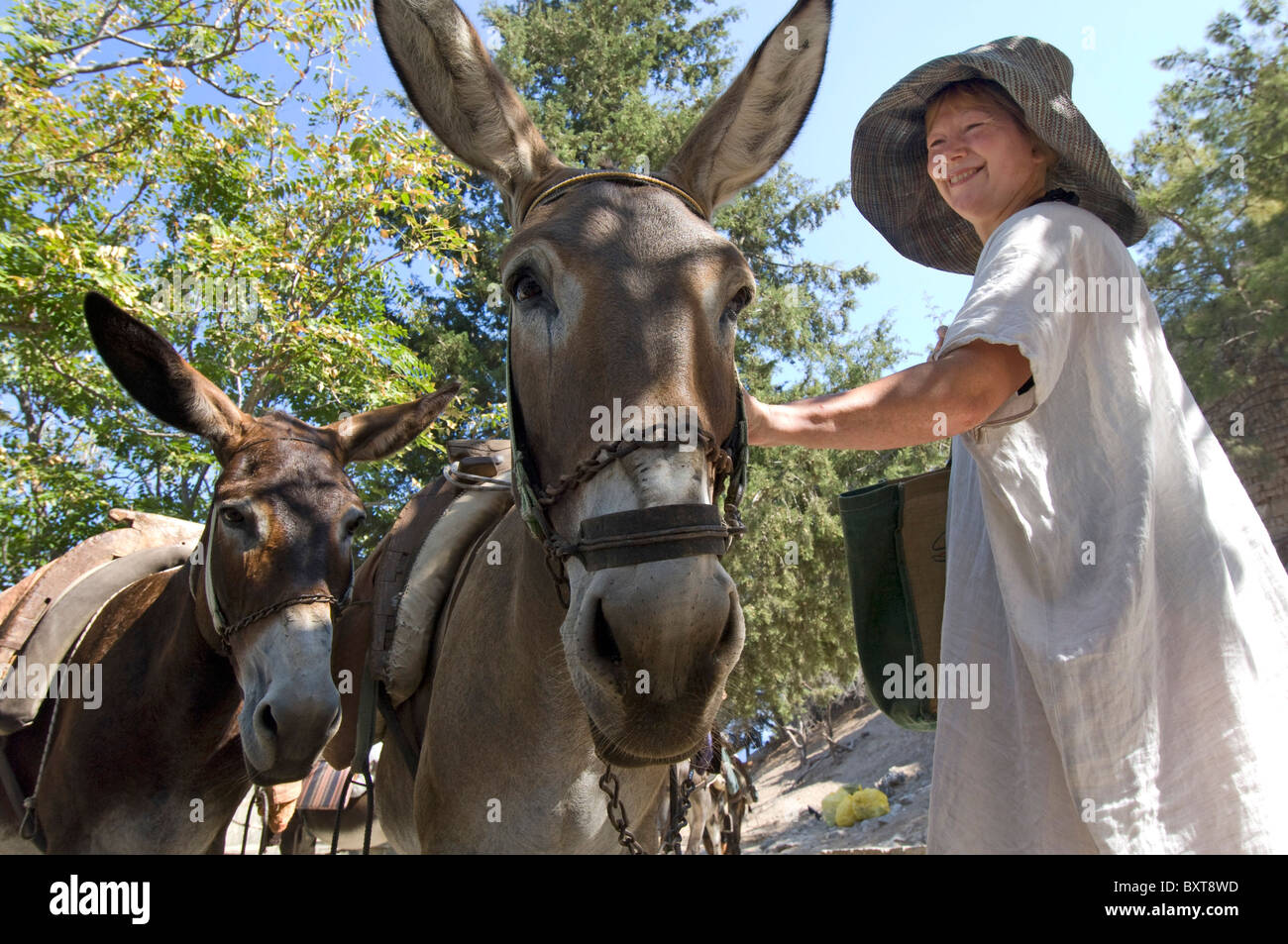 La femme d'âge moyen en tapotant sur l'âne île grecque de Rhodes. Banque D'Images