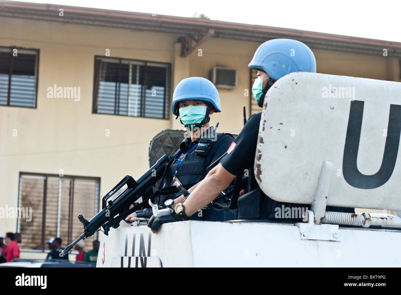 Un véhicule de l'ONU et les soldats offrent une protection à un organisme d'aide humanitaire la distribution de nourriture en Haïti. Banque D'Images