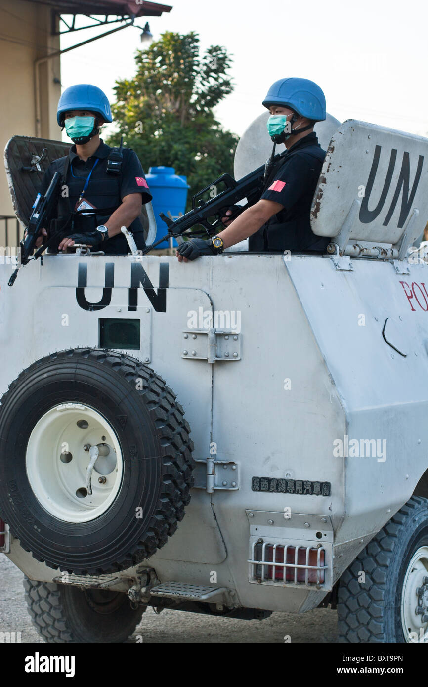 Un véhicule de l'ONU et les soldats offrent une protection à un organisme d'aide humanitaire la distribution de nourriture en Haïti. Banque D'Images