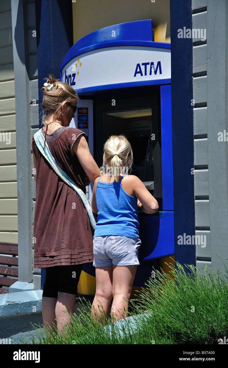 Mère et fille au distributeur automatique de la machine à la Direction générale de BNZ, Rue Balguerie, Akaroa, la péninsule de Banks, Canterbury, Nouvelle-Zélande Banque D'Images