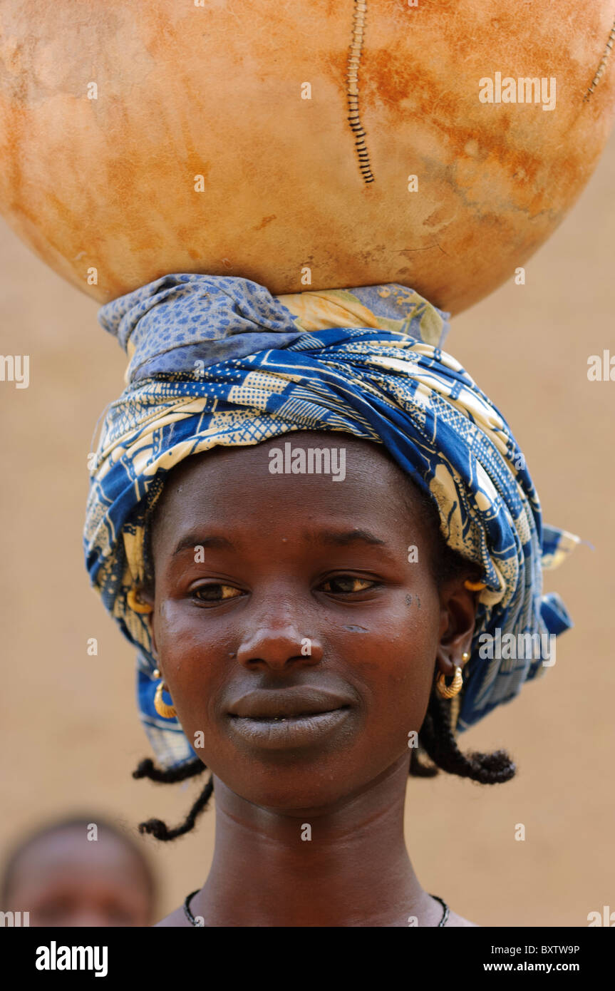 Portrait de femme Peul transportant une calebasse sur la tête. Djenné, Mali Banque D'Images