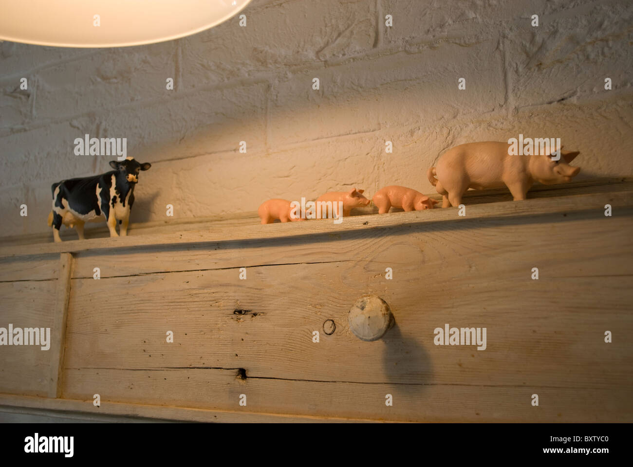 Les animaux de ferme en plastique sur l'étagère en bois dans la cuisine Banque D'Images