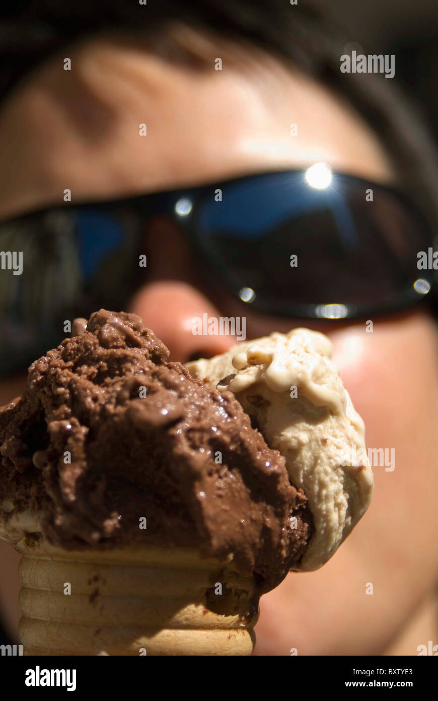 Femme avec des lunettes Eating Ice Cream Banque D'Images