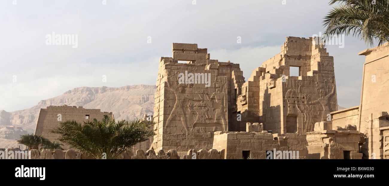 Vue panoramique sur l'temple funéraire du pharaon Ramsès III, Médinet Habou, en face de collines thébaine, rive ouest de Louxor, Egypte Banque D'Images