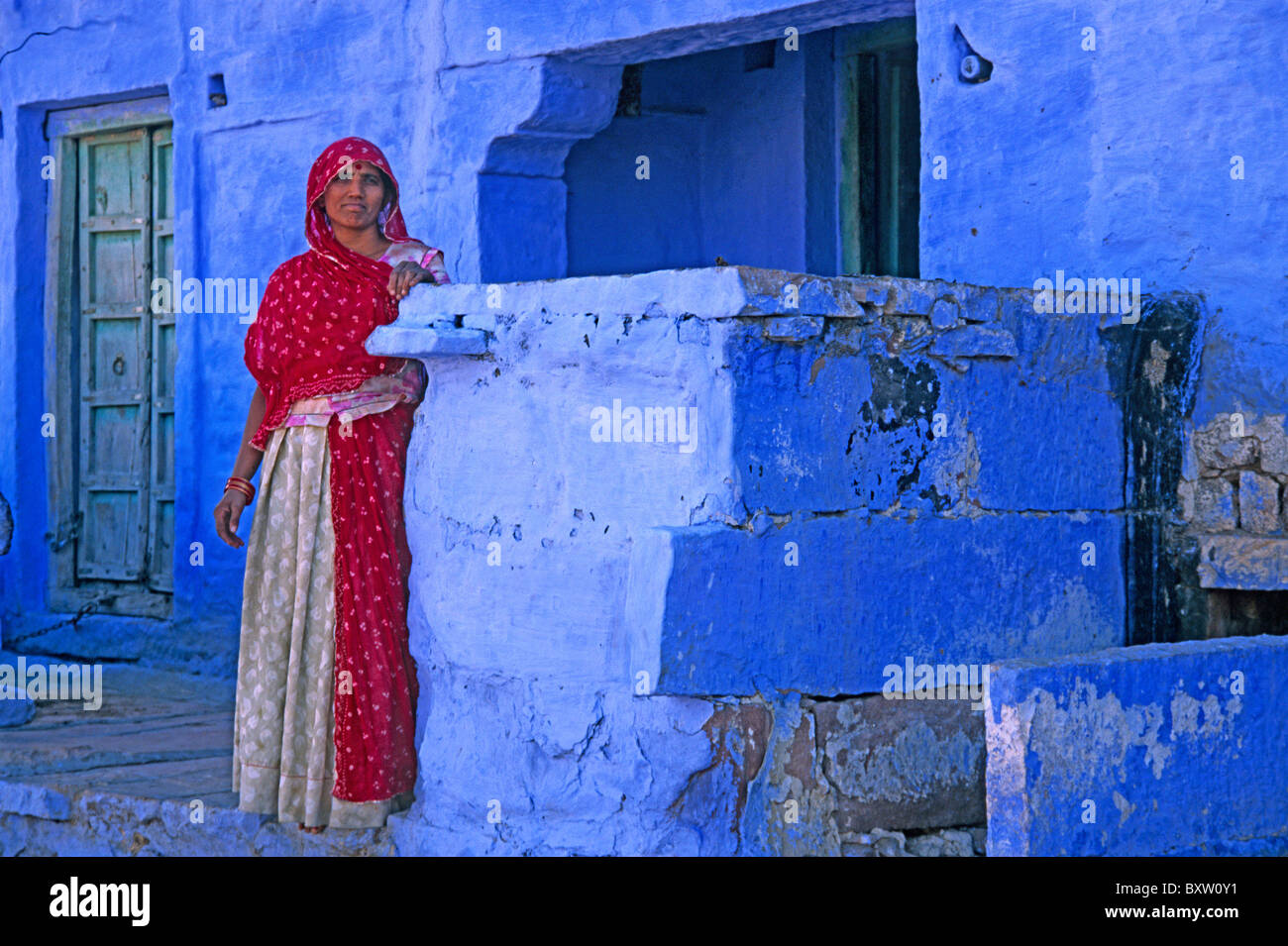 Femme sur le porche d'une maison dans la ville bleue, Jodhpur, Rajasthan, India Banque D'Images