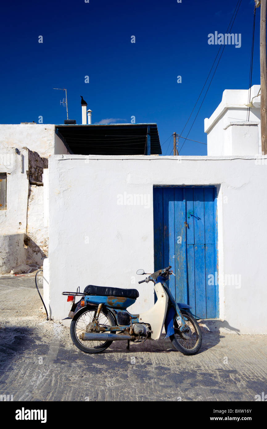 Scooter Yamaha rouillé garé en face d'une maison typique des Cyclades en Marmara, sur l'île de Paros Cyclades grecques. Banque D'Images