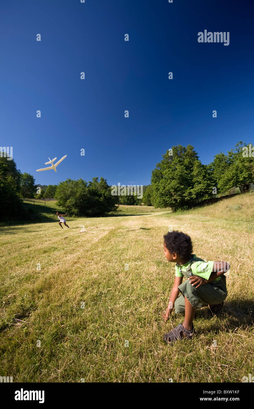 Enfants jouant avec un modèle d'avion (France). Frère et soeur jouant avec un modèle réduit d'avion (France). Banque D'Images