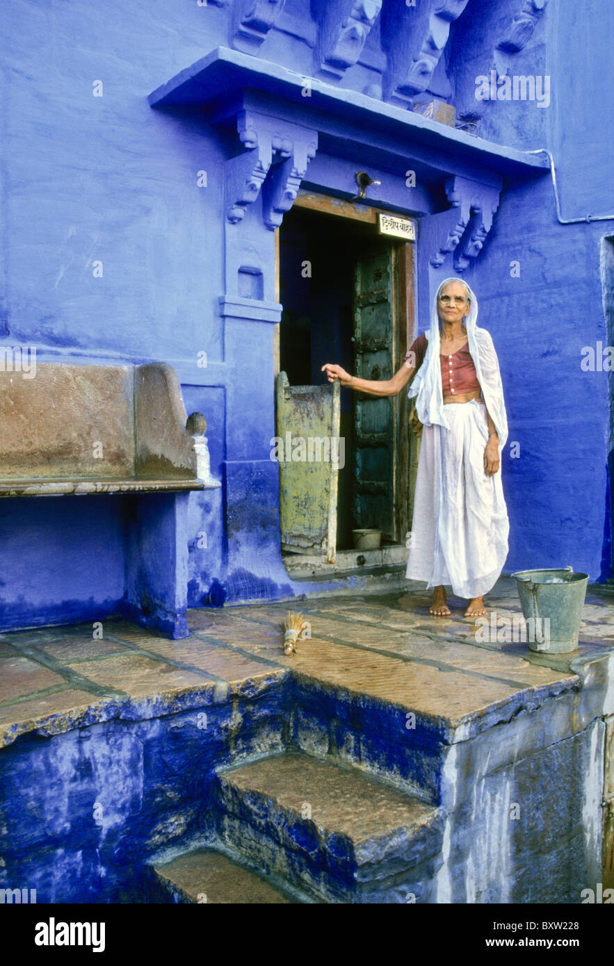 Femme sur le porche d'une maison dans la ville bleue, Jodhpur, Rajasthan, India Banque D'Images
