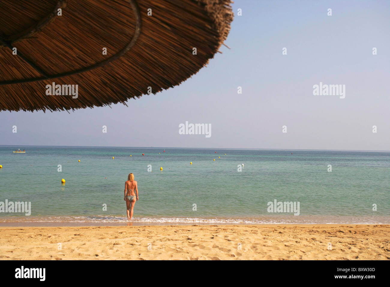 Femme Debout dans l'eau On Beach Banque D'Images