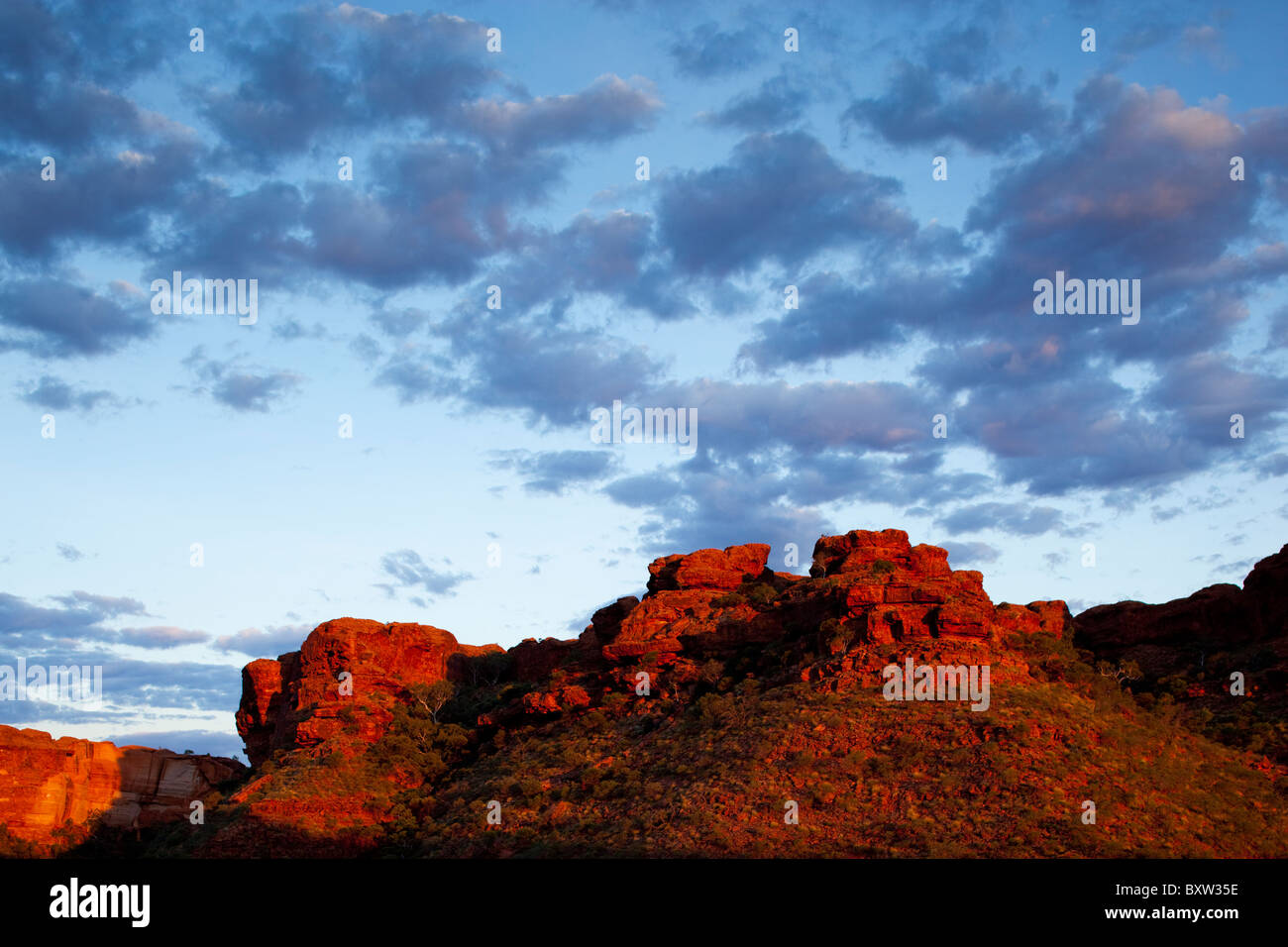 L'Australie, Territoire du Nord, le parc national de Watarrka, Coucher de soleil s'allume rouge murs de grès de Kings Canyon sur soirée d'été Banque D'Images