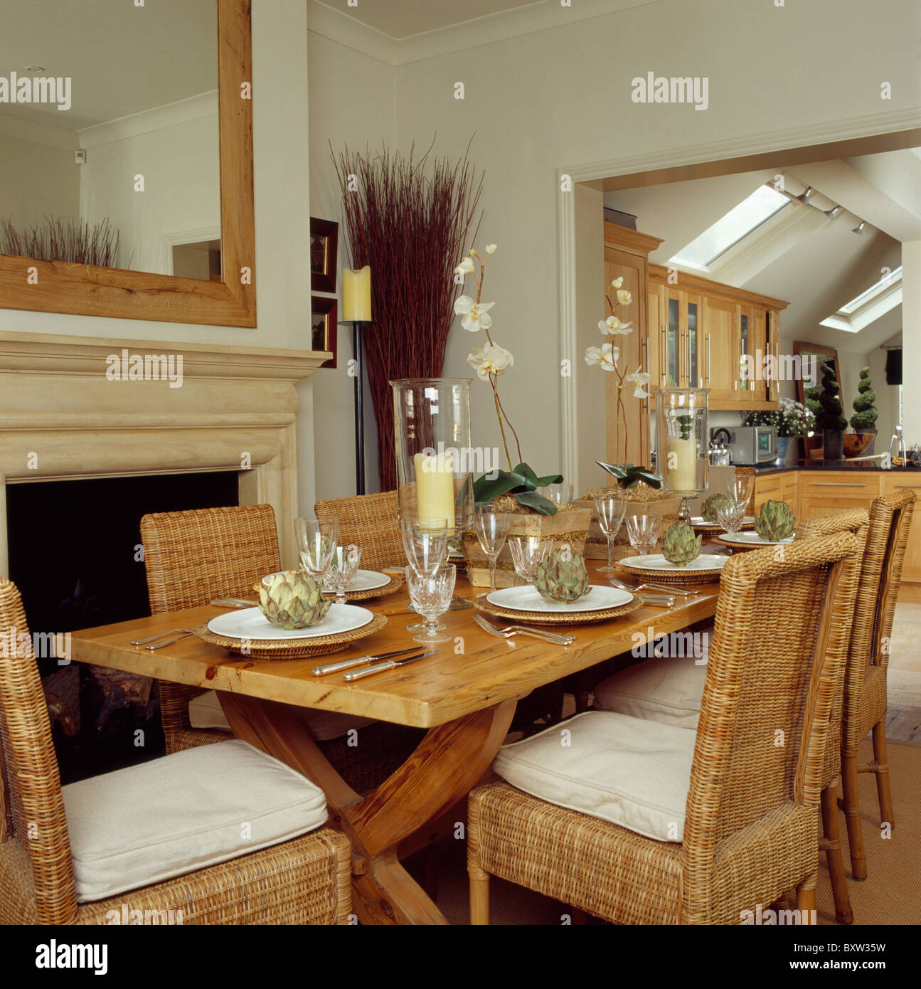 Chaises en rotin et table en bois simple crème en salle à manger avec porte de cuisine Banque D'Images