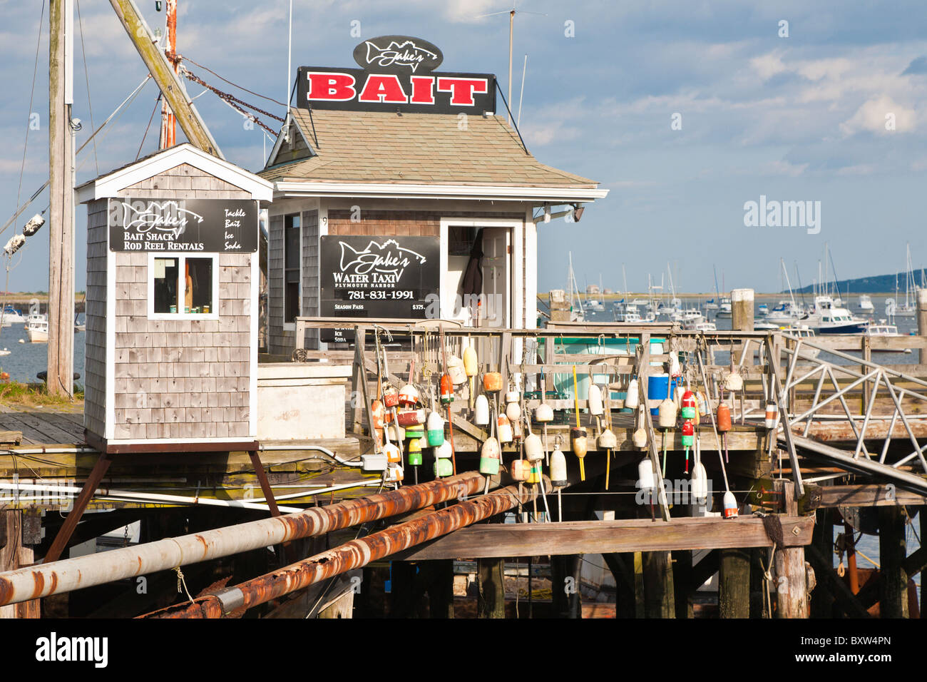 Accrocher les bouées de homard sur main courante en face de Jake's Water Taxi et Bait shop sur le quai de la ville de Plymouth au Massachusetts Banque D'Images