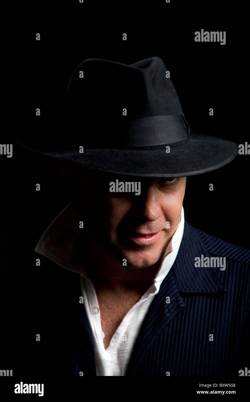 Un mâle adulte artiste chanteur portant un chapeau Fedora noir style  Timberlake et veste en daim bleu avec éclairage à faible clés Photo Stock -  Alamy