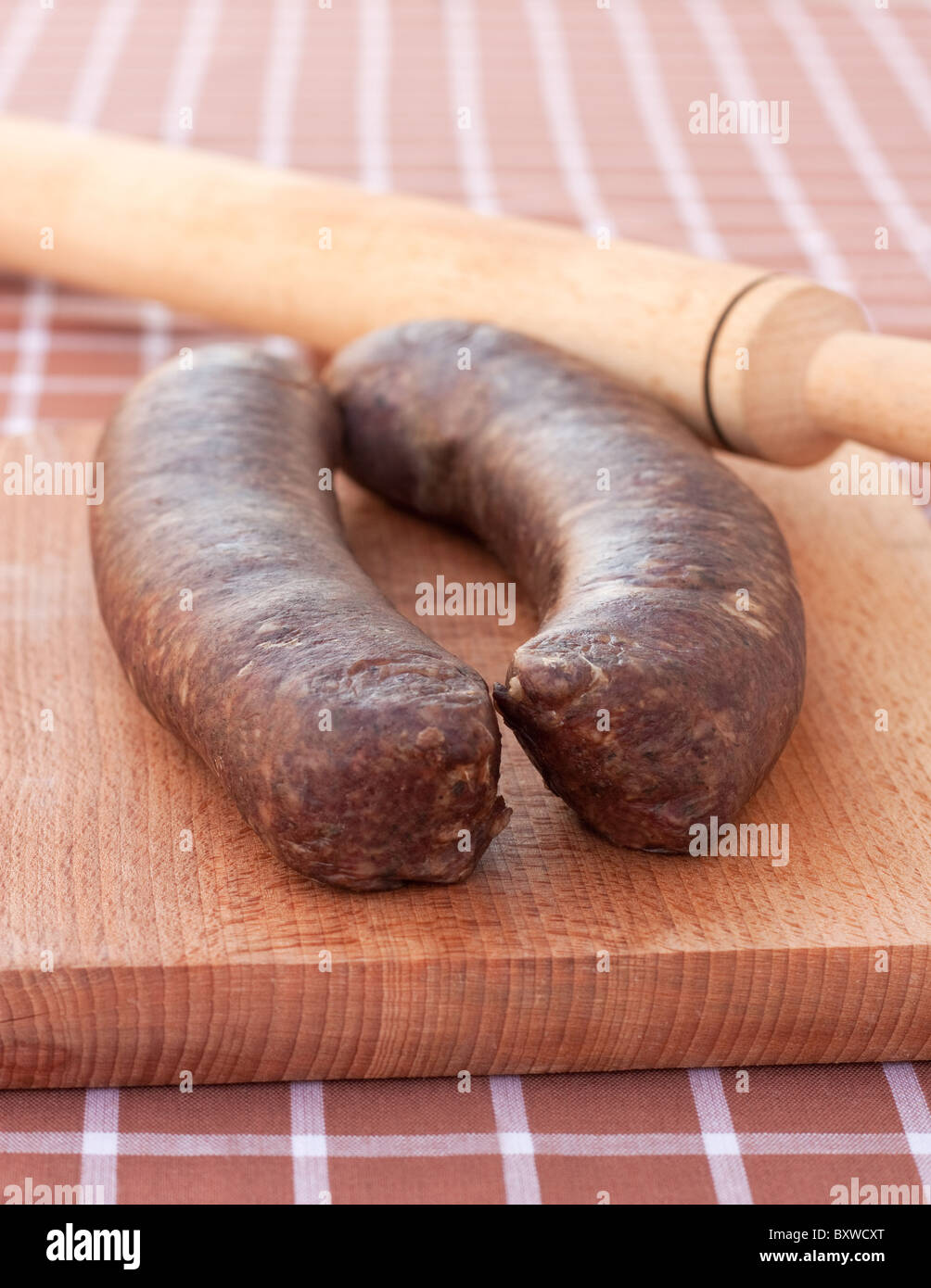 Saucisses faites maison,prêt à être roulé avec roulement-pin sur planche à découper en bois Banque D'Images