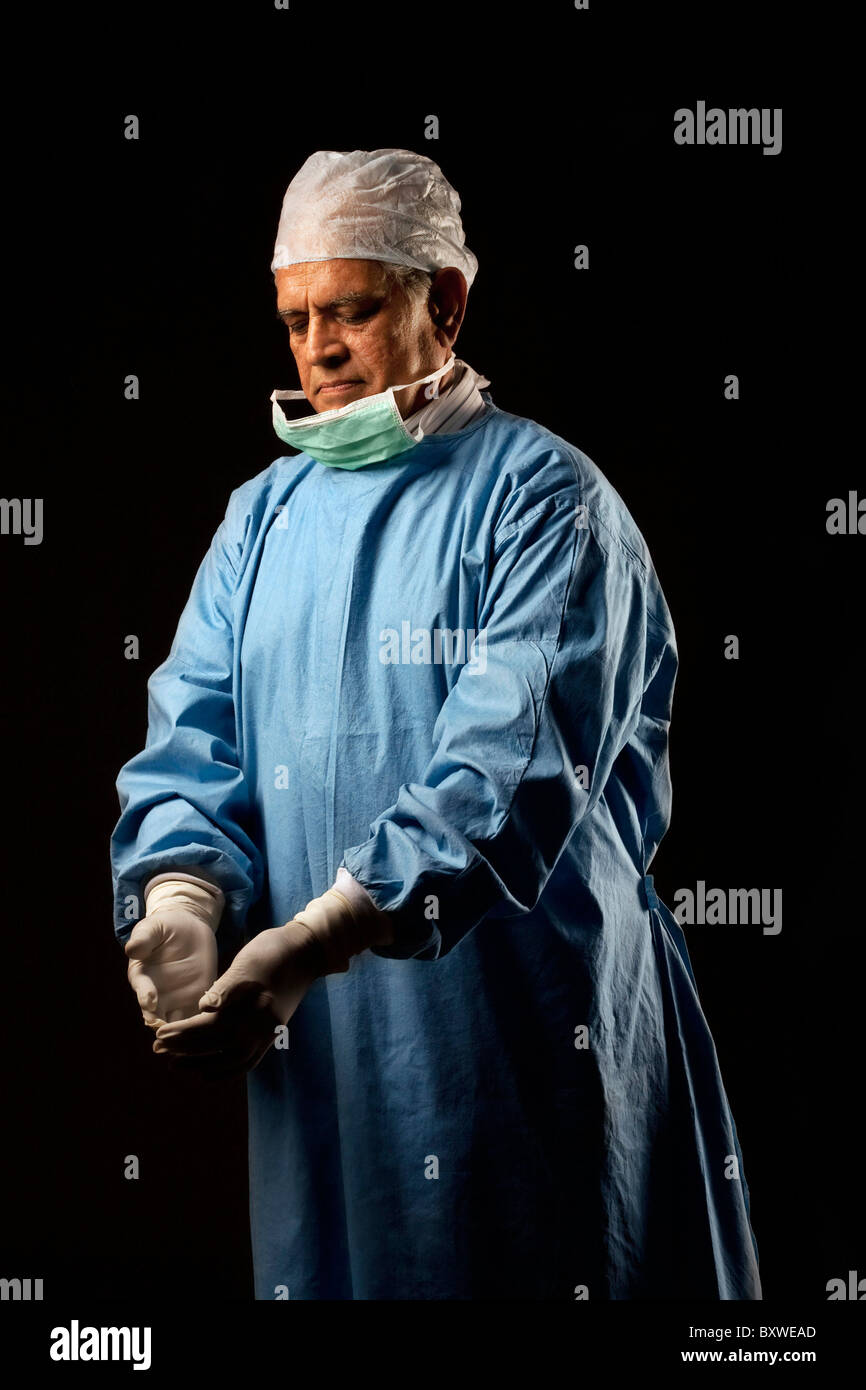 Chirurgien regarde ses gants Banque D'Images