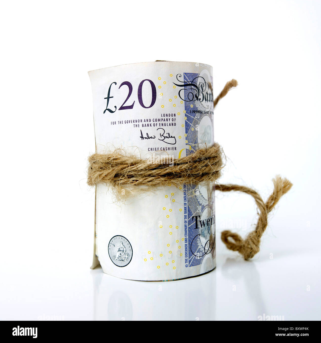 Roula tas de livre sterling UK British billets ligoté et attaché avec une chaîne de caractères / corde Banque D'Images