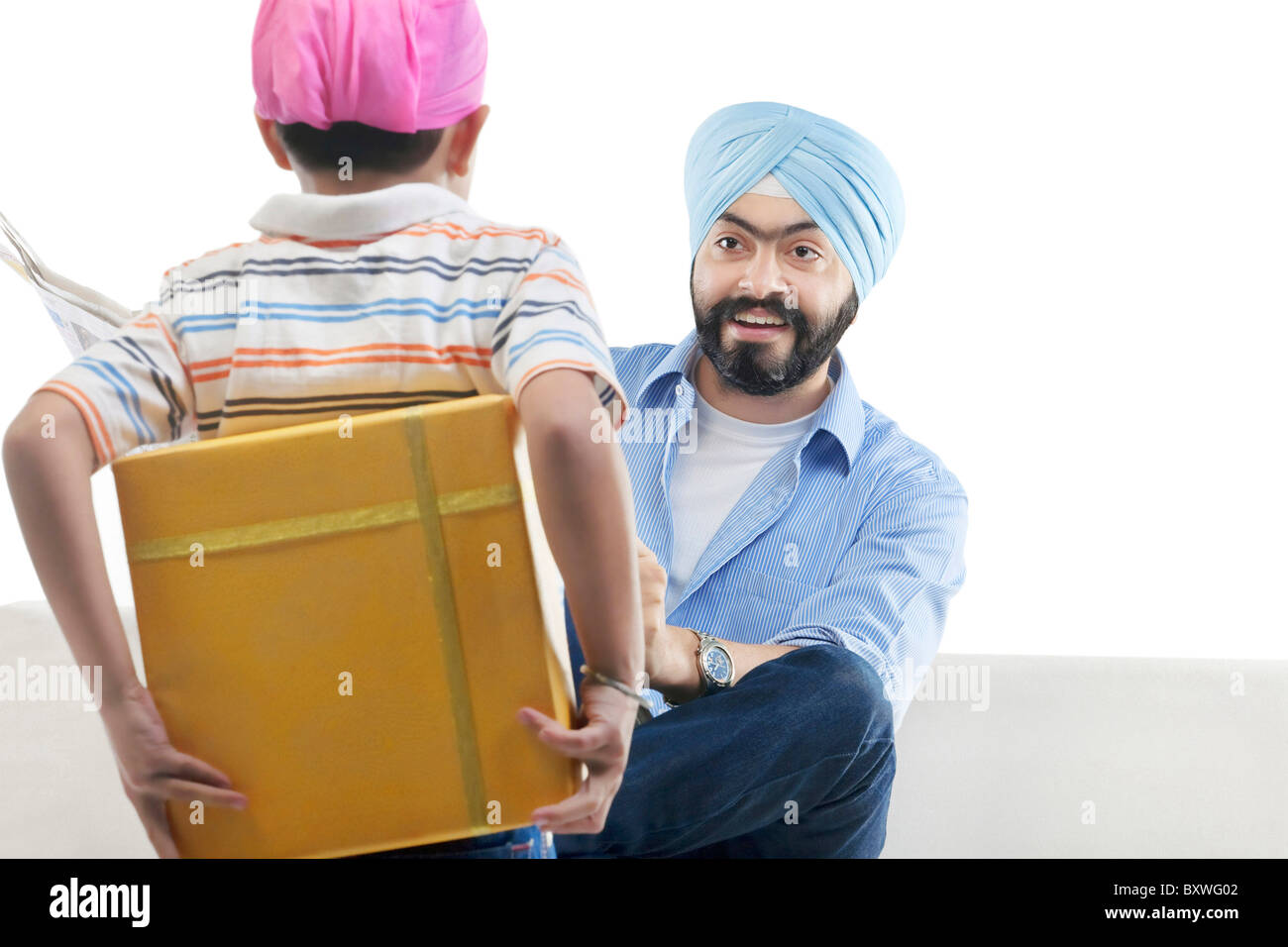 Garçon Sikh de cacher un cadeau de son père Banque D'Images