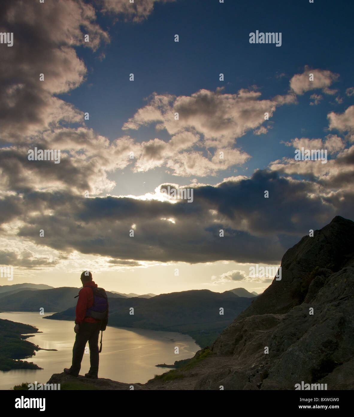 Walker à la recherche sur le Loch Katrine au coucher du soleil Banque D'Images