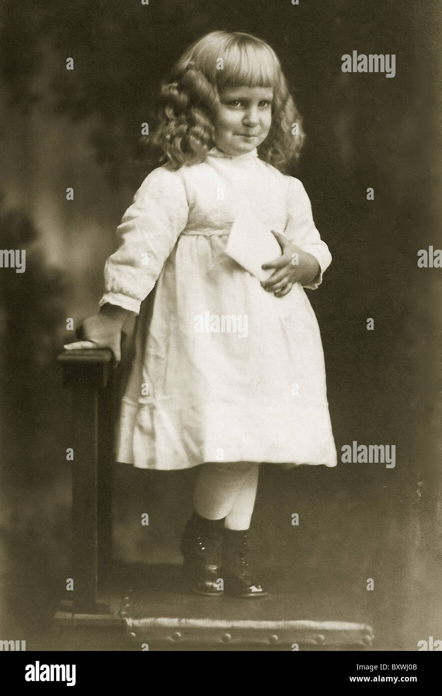 Image antique d'un petit garçon avec de longues boucles portant une robe. c. 1900 Banque D'Images