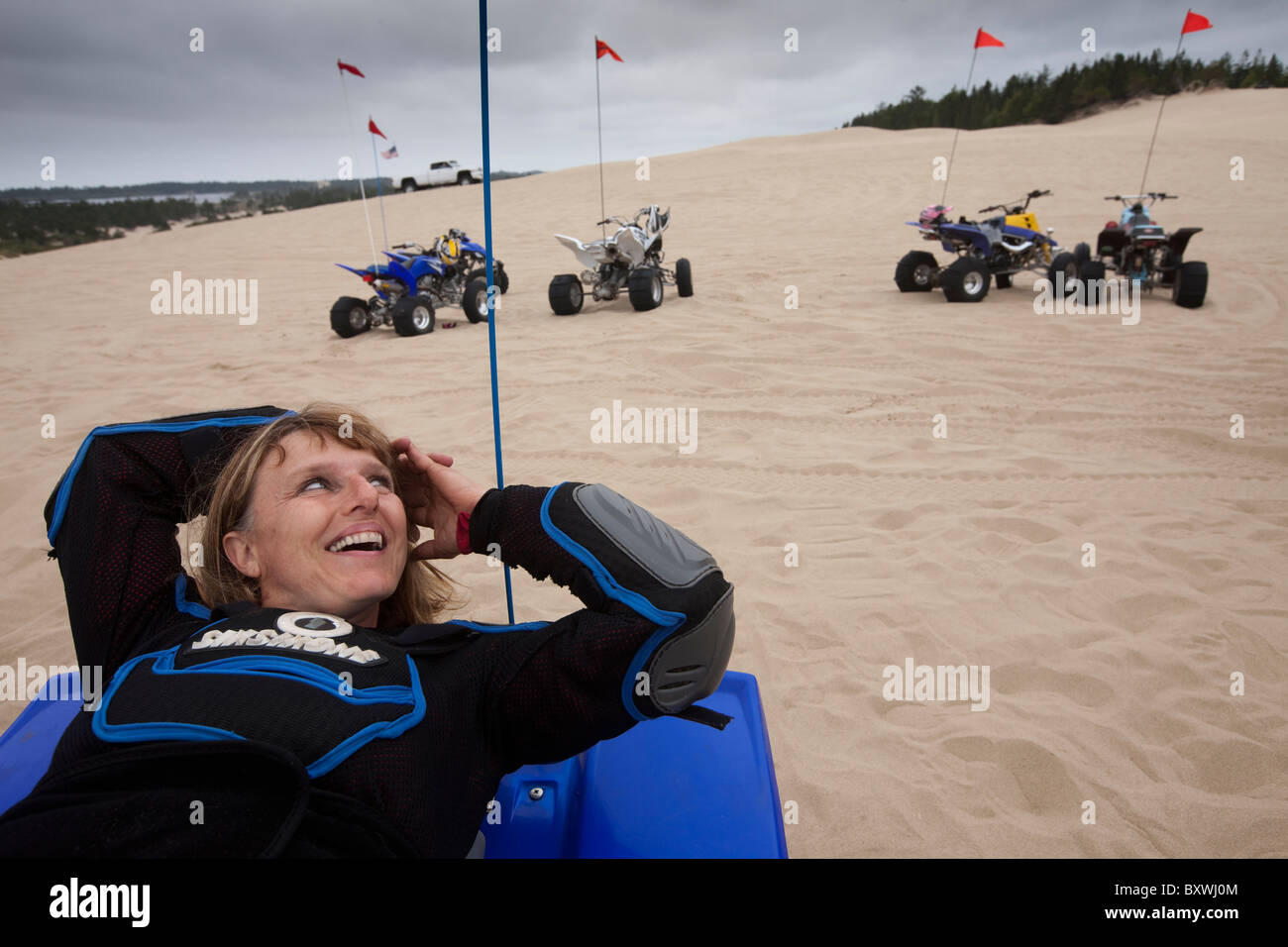 USA, New York, North Bend, Becky Selba repose tout en montant son VTT sur les dunes de sable de l'Oregon Dunes National Recreation Area Banque D'Images