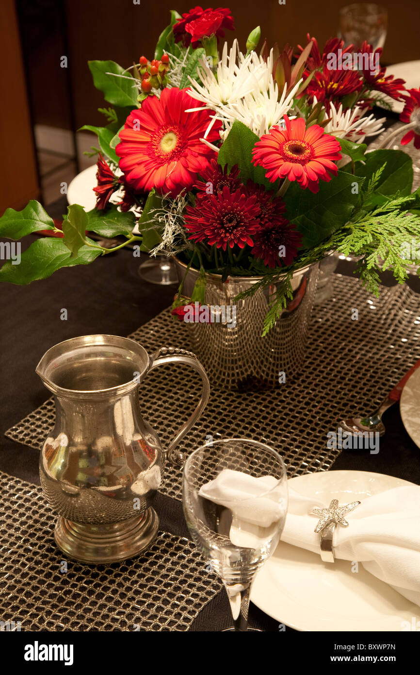 Réglage de la table avec arrangement de fleurs sur une nappe noire en attendant le dîner, vous Banque D'Images