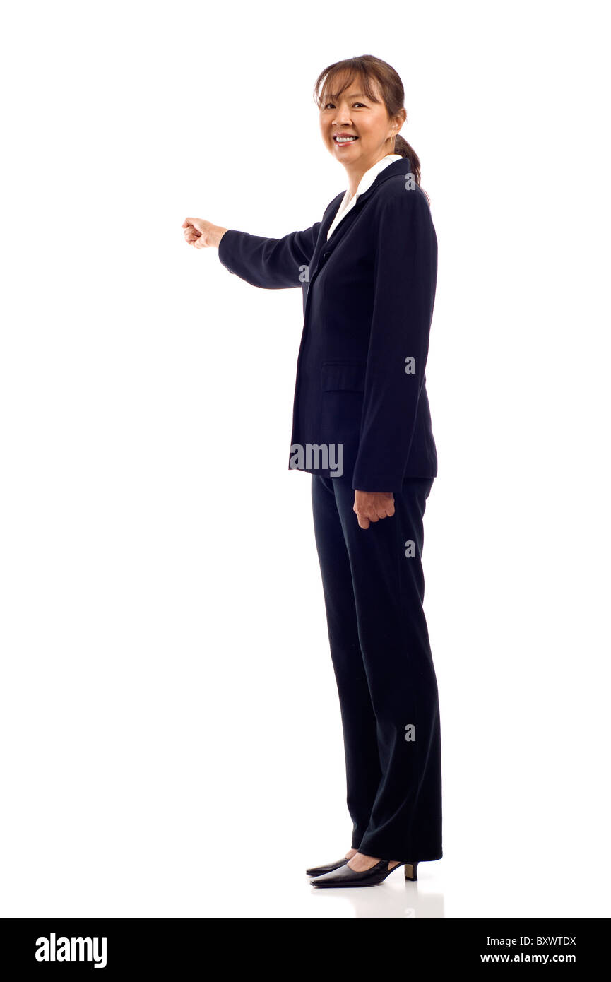 Smiling mature Asian business woman pointing at something over white Banque D'Images