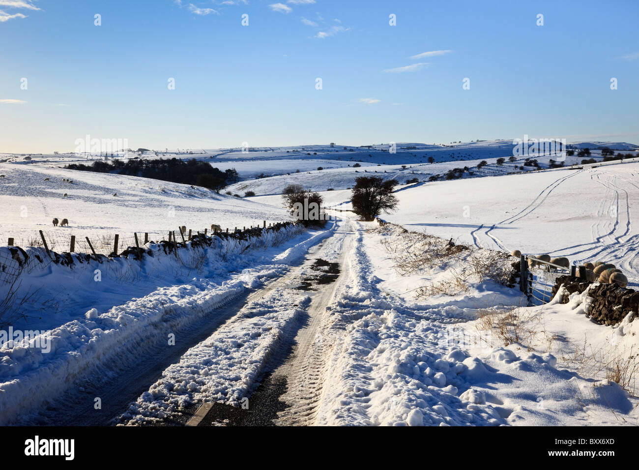 Le Derbyshire, Angleterre, Royaume-Uni. Pays couverts de neige lane avec voiture traque Banque D'Images