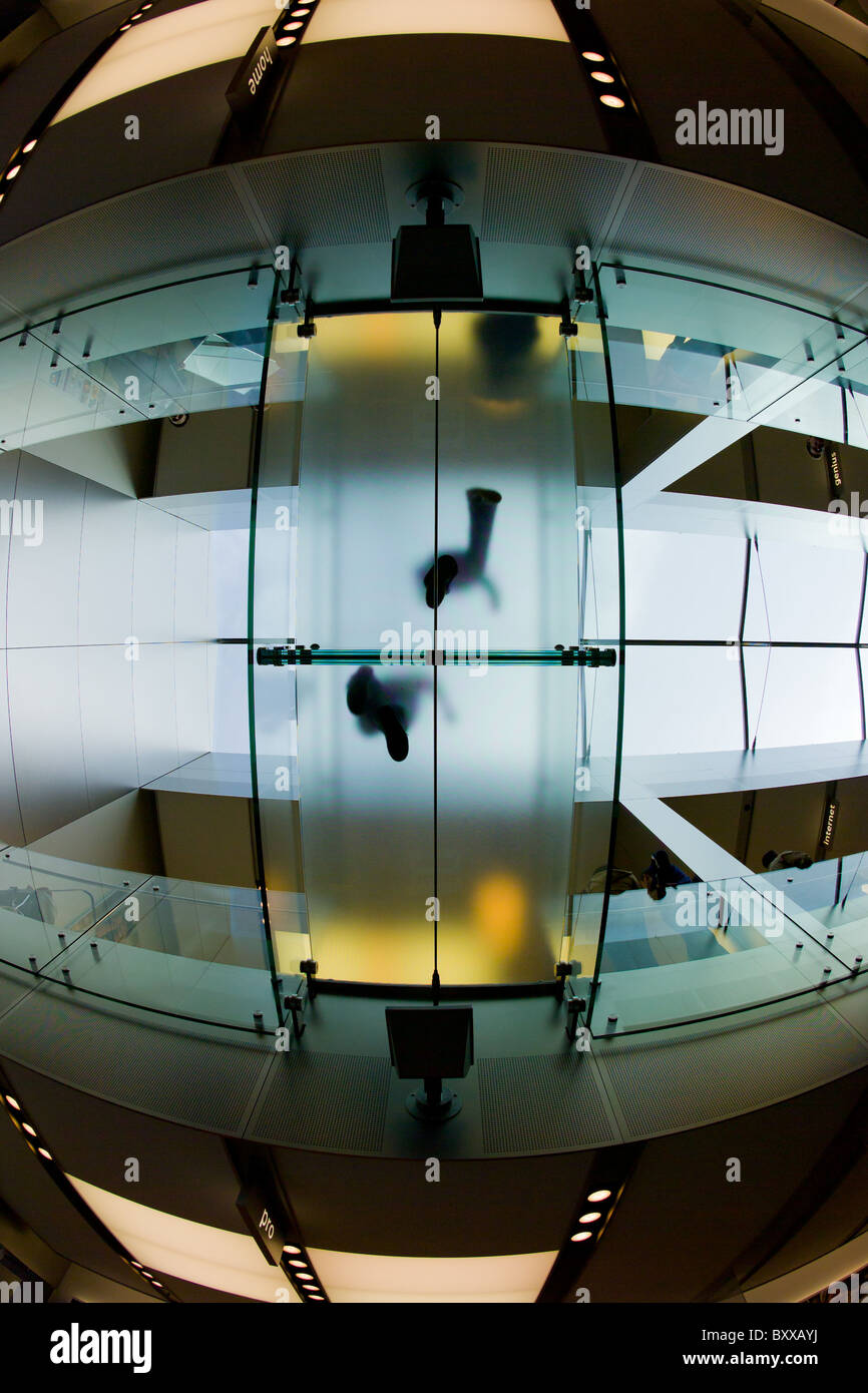 Deux figures debout sur pont en verre dans l'Apple Store de San Francisco tourné de dessous avec objectif fisheye. Banque D'Images